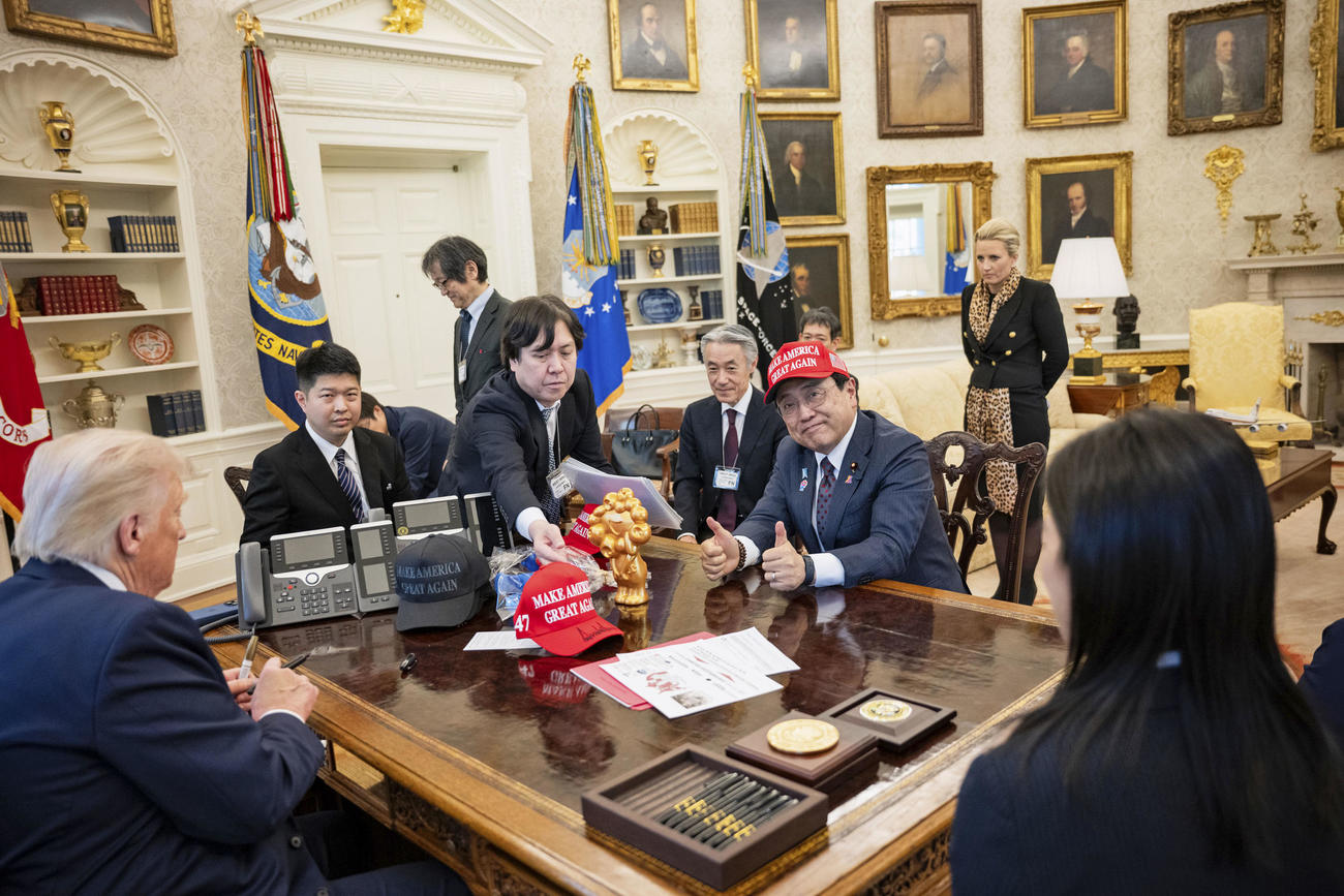 ホワイトハウスで開かれたトランプ米大統領（手前左）との会談でMAGA帽子をかぶった赤沢経済再生相（ホワイトハウス提供、共同）
