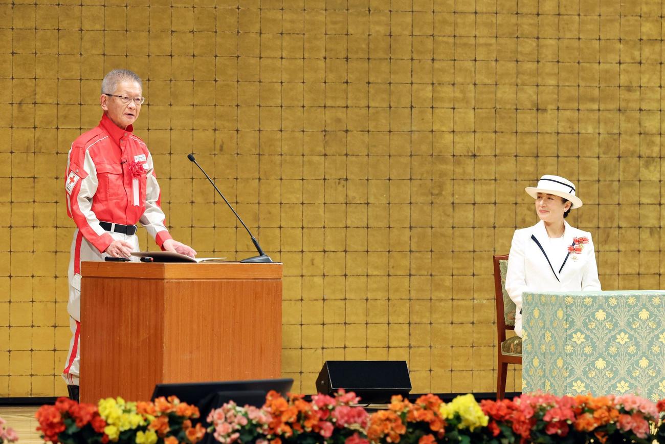 全国赤十字大会で活動報告をする稲田真治さん（左）と皇后さま＝13日午前、東京都渋谷区の明治神宮会館（代表撮影）