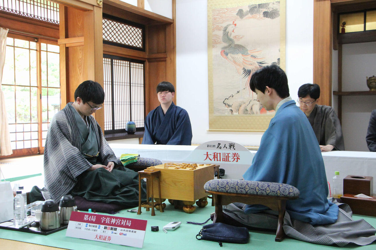 名人戦では6年ぶりの千日手が成立し、立会人の谷川浩司17世名人の説明を聞く藤井聡太名人（右）永瀬拓矢九段（日本将棋連盟提供）