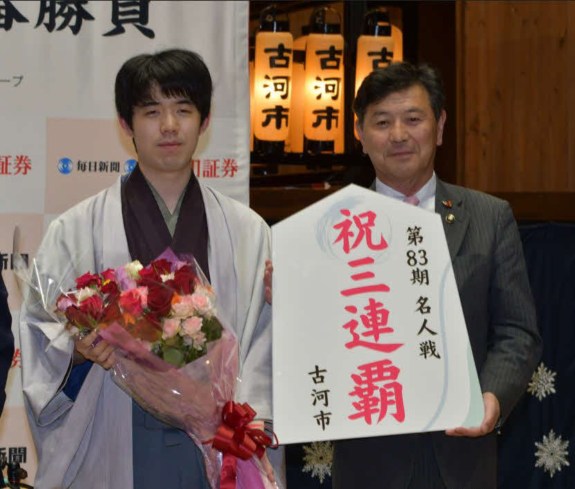 名人戦3連覇を達成した藤井聡太名人（左）は地元の針谷力古河市長（右）から祝福を受ける