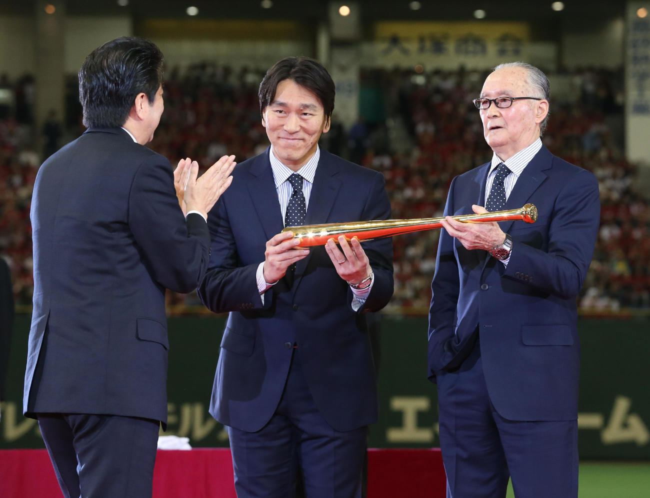 国民栄誉賞の授与式で、安倍晋三首相（左）から金のバットを授与される長嶋茂雄氏（右）と介添えする松井秀喜氏＝2013年5月5日　代表撮影