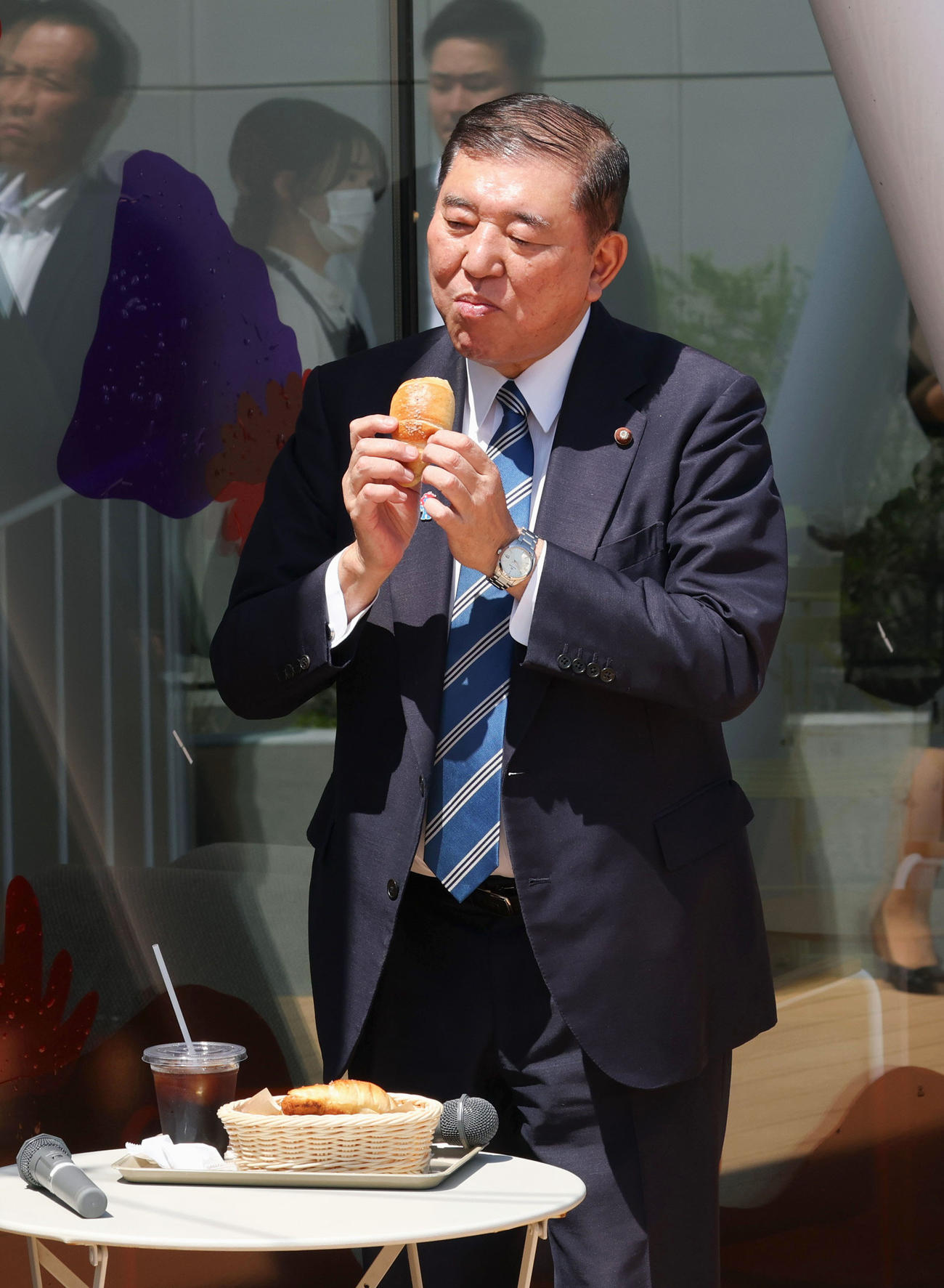 「ジンズパーク」で販売されているパンを食べる石破首相
