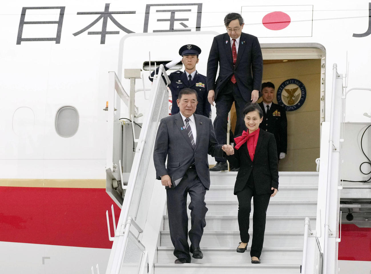 G7サミット出席のため、カナダ・カルガリー国際空港に到着した石破首相。右は妻の佳子さん（共同）