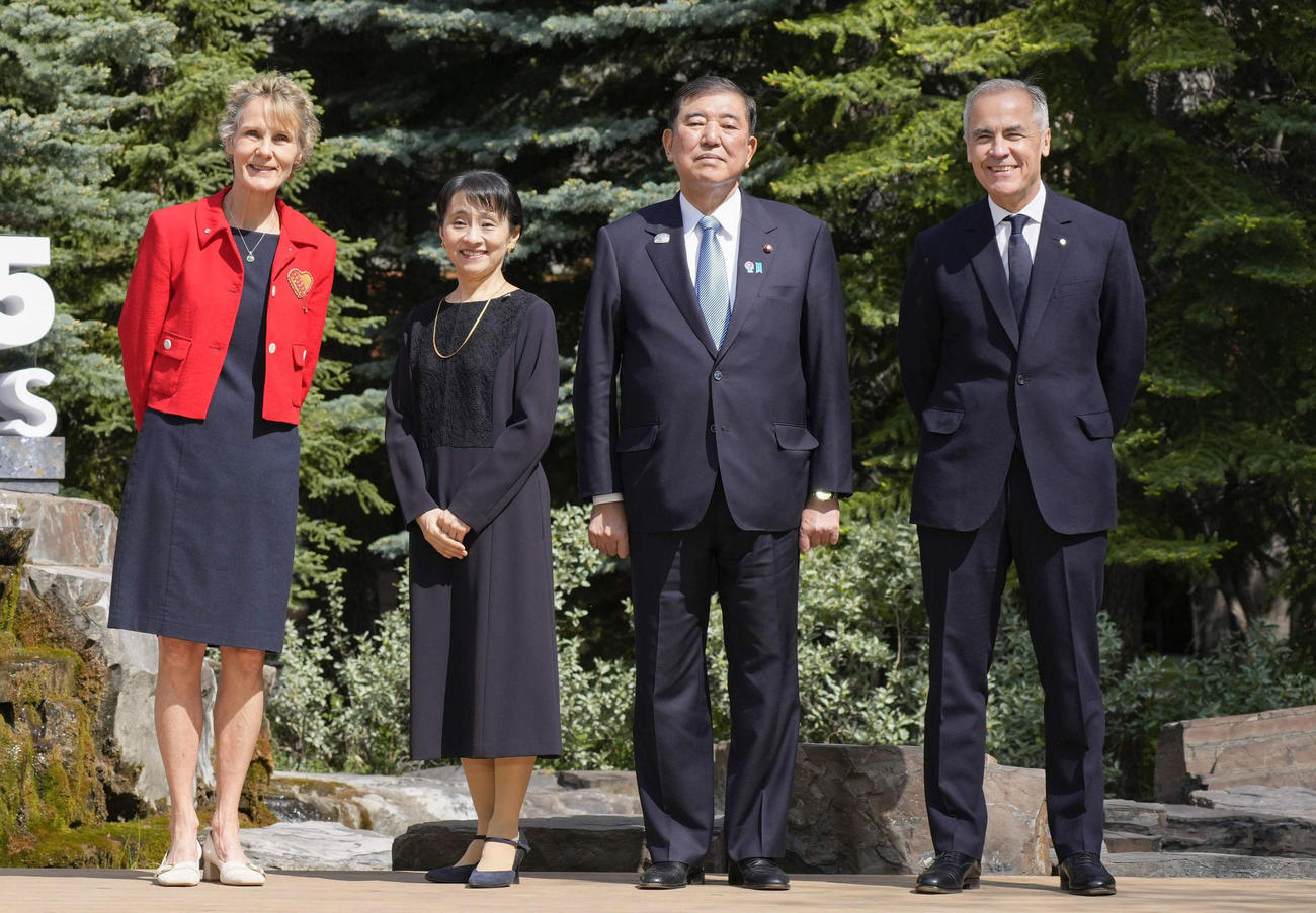 G7サミット会場のカナダ西部カナナスキスで、カナダのカーニー首相（右端）の出迎えを受け記念写真に納まる石破首相（右から2人目）＝16日（共同）