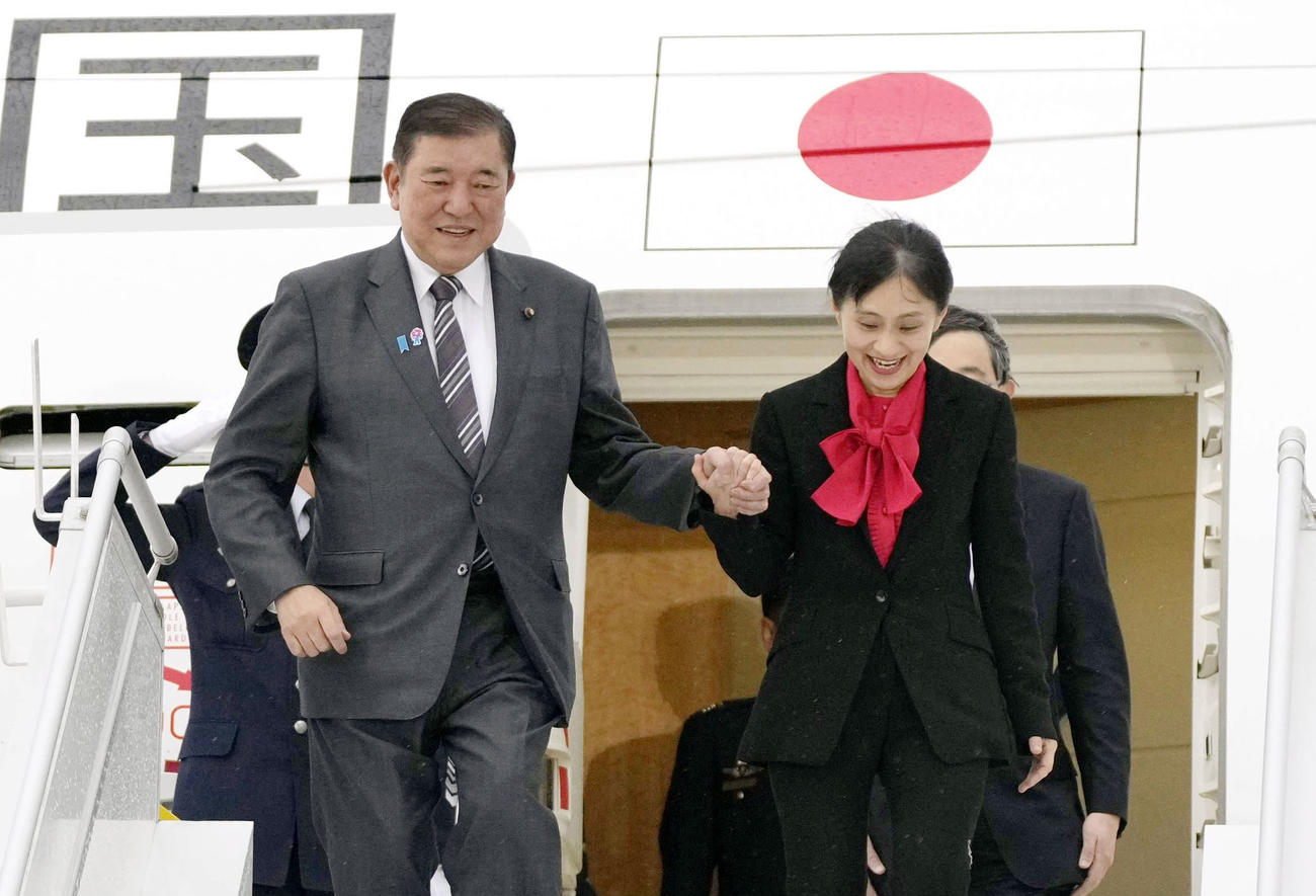 G7サミット出席のため、カナダのカルガリー国際空港に到着した石破首相。右は妻の佳子さん（共同）