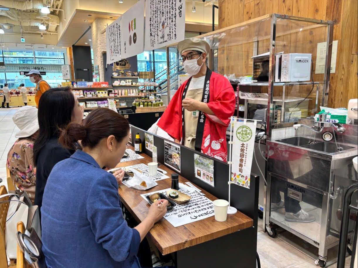 イートインスペースで田舎ずしや土佐巻き、日本酒を楽しむ来店客
