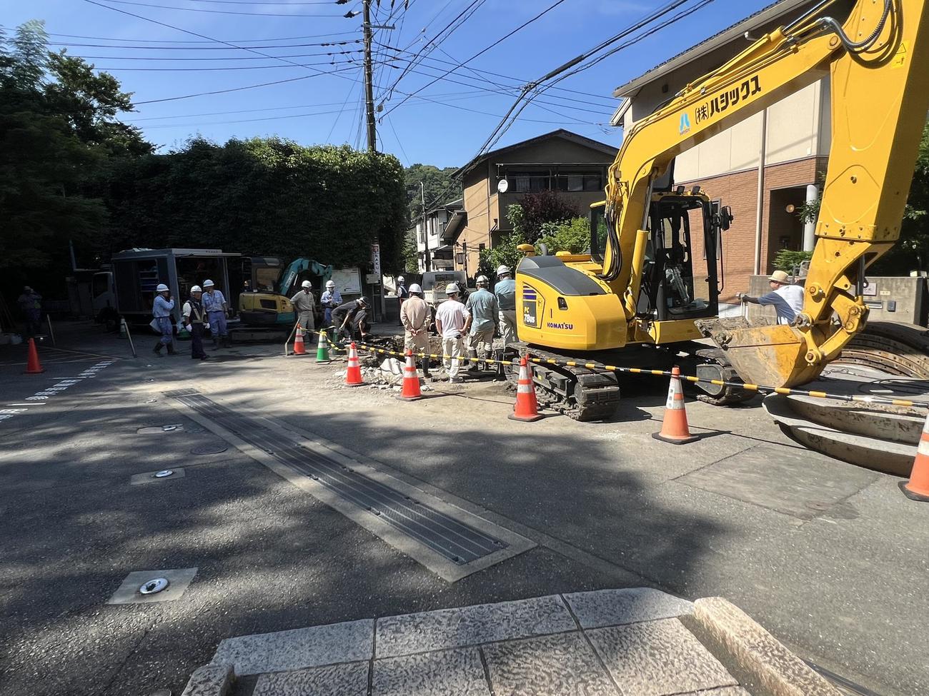 鎌倉市で、破損、漏水した水道管の修復をする作業員と持ち込まれた重機