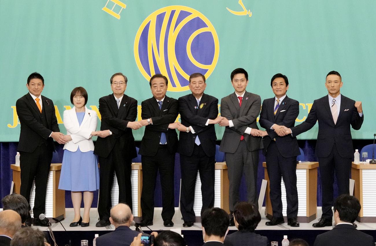 参院選公示を前に日本記者クラブ主催の討論会で手をつなぐ与野党の8党首。左から参政党の神谷代表、共産党の田村委員長、公明党の斉藤代表、立憲民主党の野田代表、自民党総裁の石破首相、日本維新の会の吉村代表、国民民主党の玉木代表、れいわ新選組の山本代表（共同）