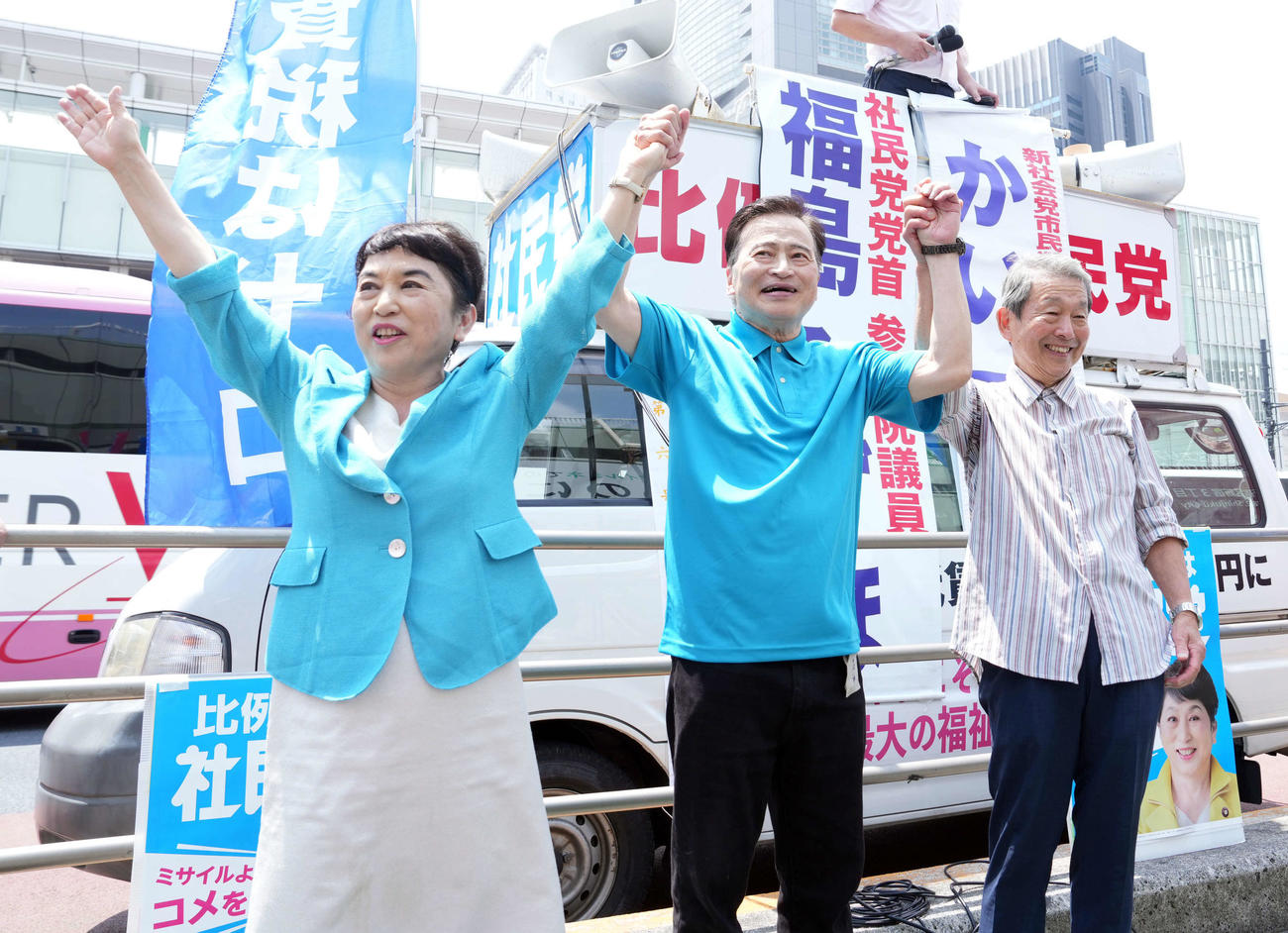聴衆の声援に応える、左から社民党の福島瑞穂党首、ラサール石井氏、花岡蔚氏（撮影・たえ見朱実）