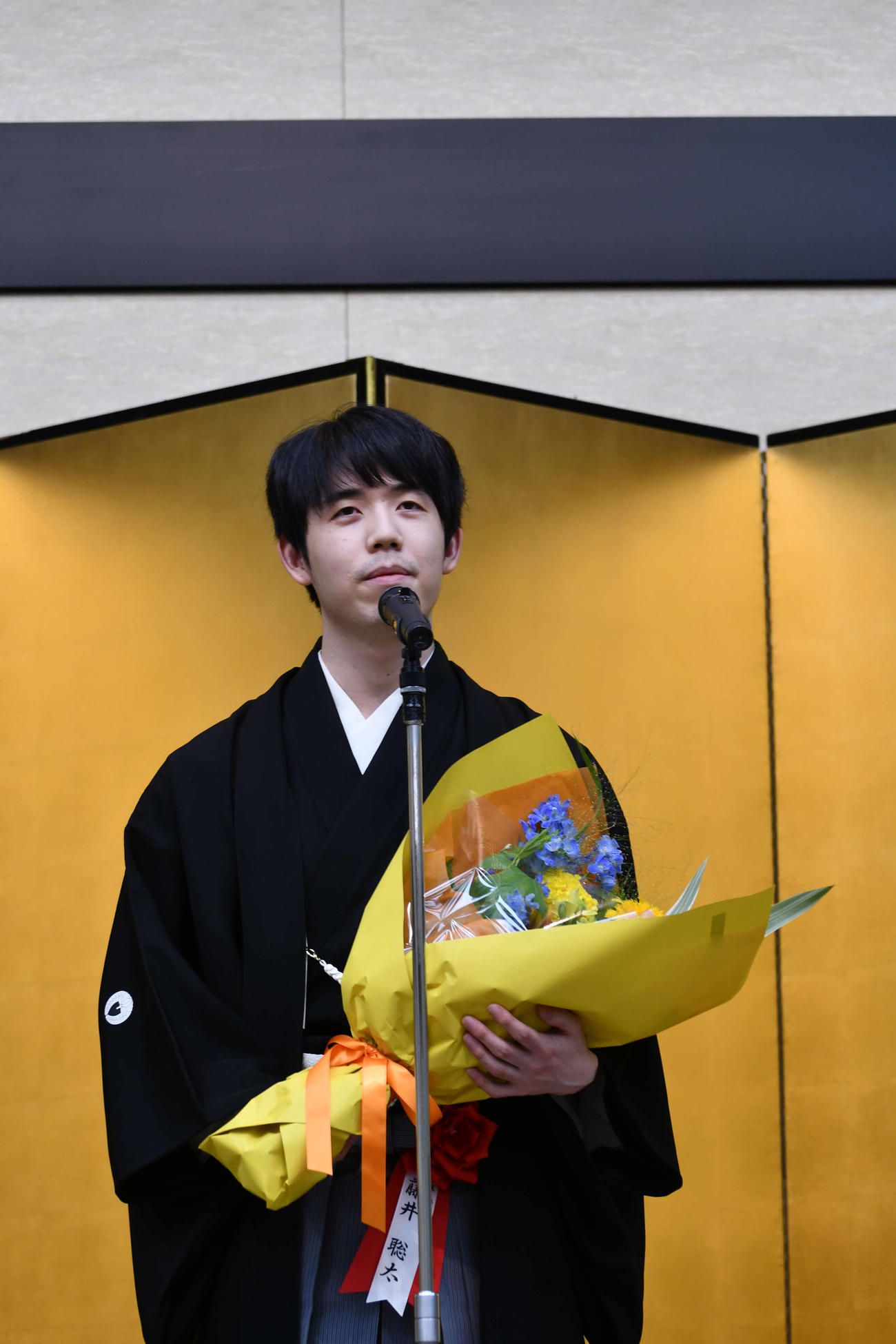 王将就位式で花束を手に謝辞を述べる藤井聡太王将