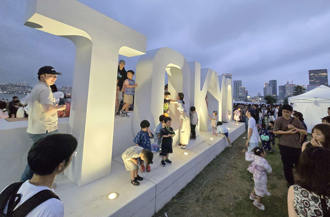 晴海フラッグの初の盆踊りが行われた晴海ふ頭公園の東京五輪のモニュメントには記念撮影で大勢の住民が集結した（撮影・寺沢卓）