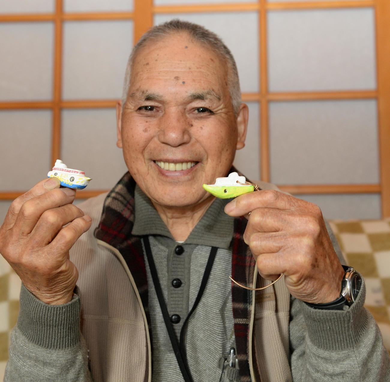 「ひまわり」をかたどったはと笛を手にする菅原進さん（2024年2月撮影）