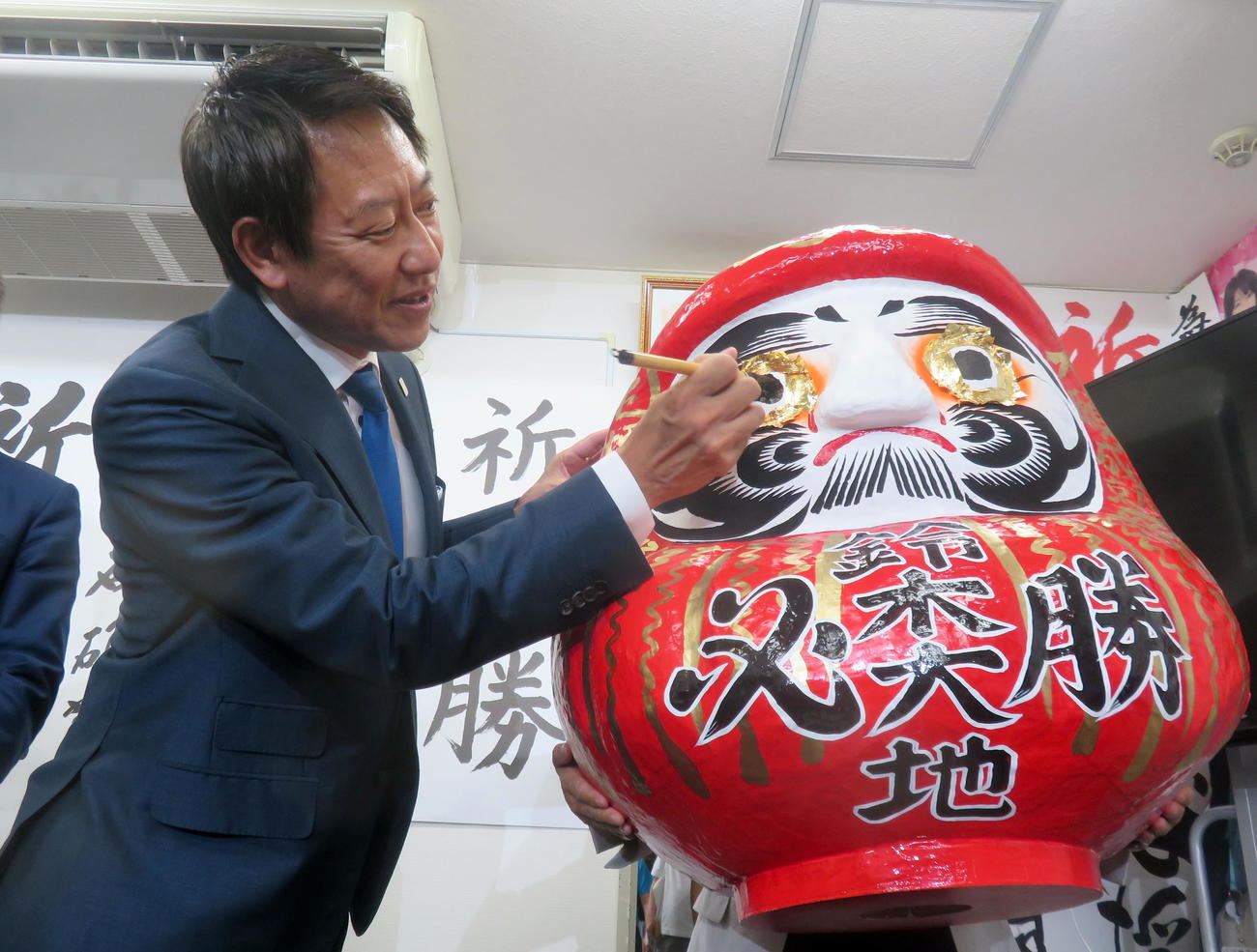 参院選で初当選し、笑顔を見せながらだるまに目を入れる鈴木大地氏（撮影・鎌田直秀）
