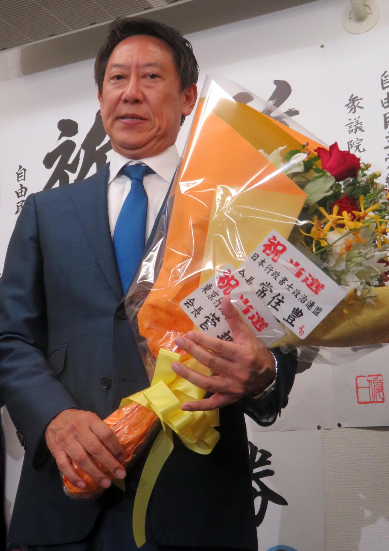参院選で初当選し、花束を抱えて安堵の表情を見せる鈴木大地氏（撮影・鎌田直秀）
