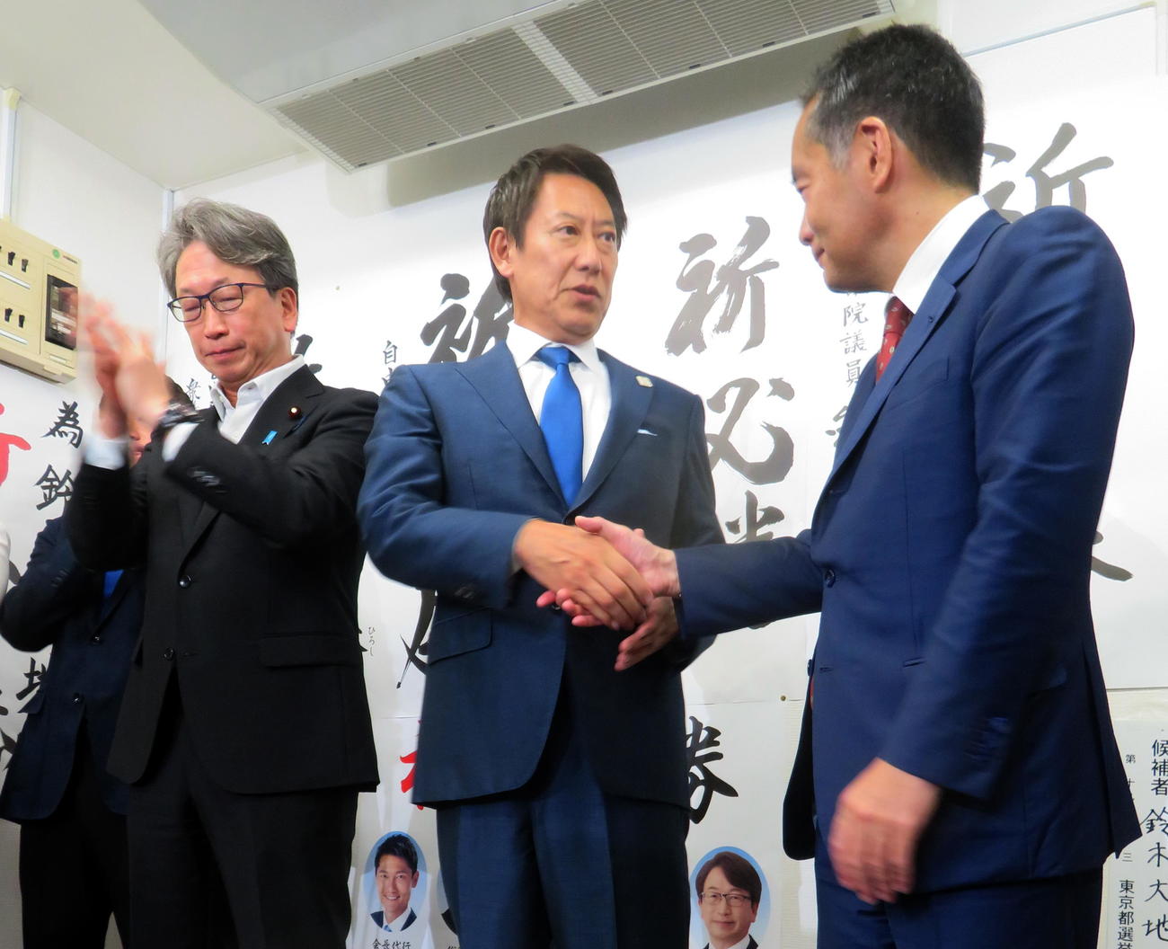 参院選で初当選し、先輩議員と握手する鈴木大地氏（中央）（撮影・鎌田直秀）
