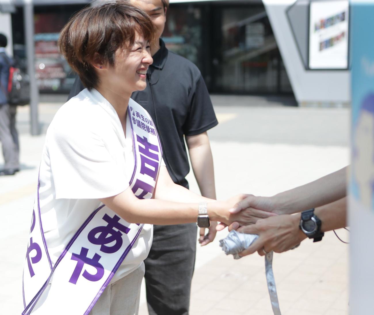 9日、JR秋葉原駅で握手をする「再生の道」吉田あや氏