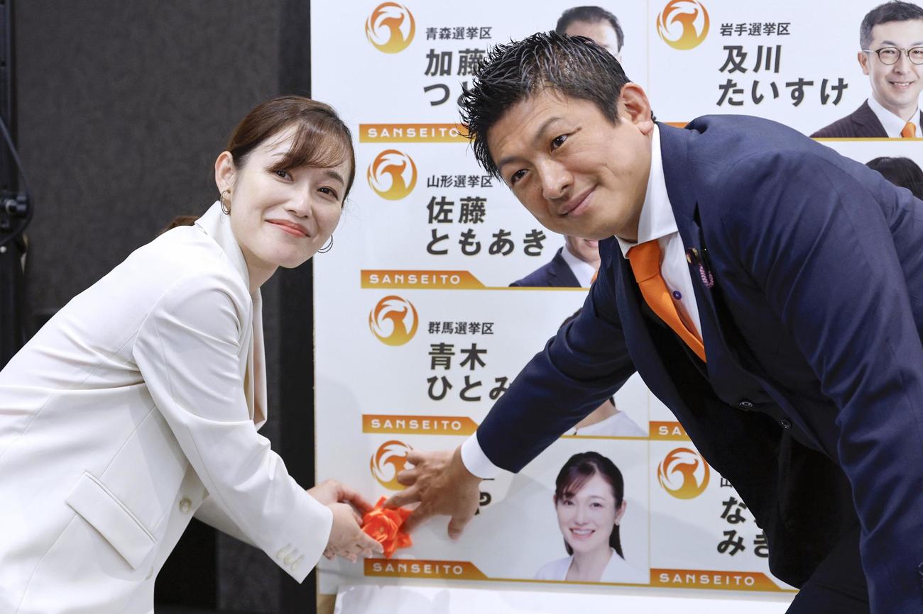 東京選挙区で当選を決めたさや氏（左）と花を付ける参政党の神谷代共同共同）