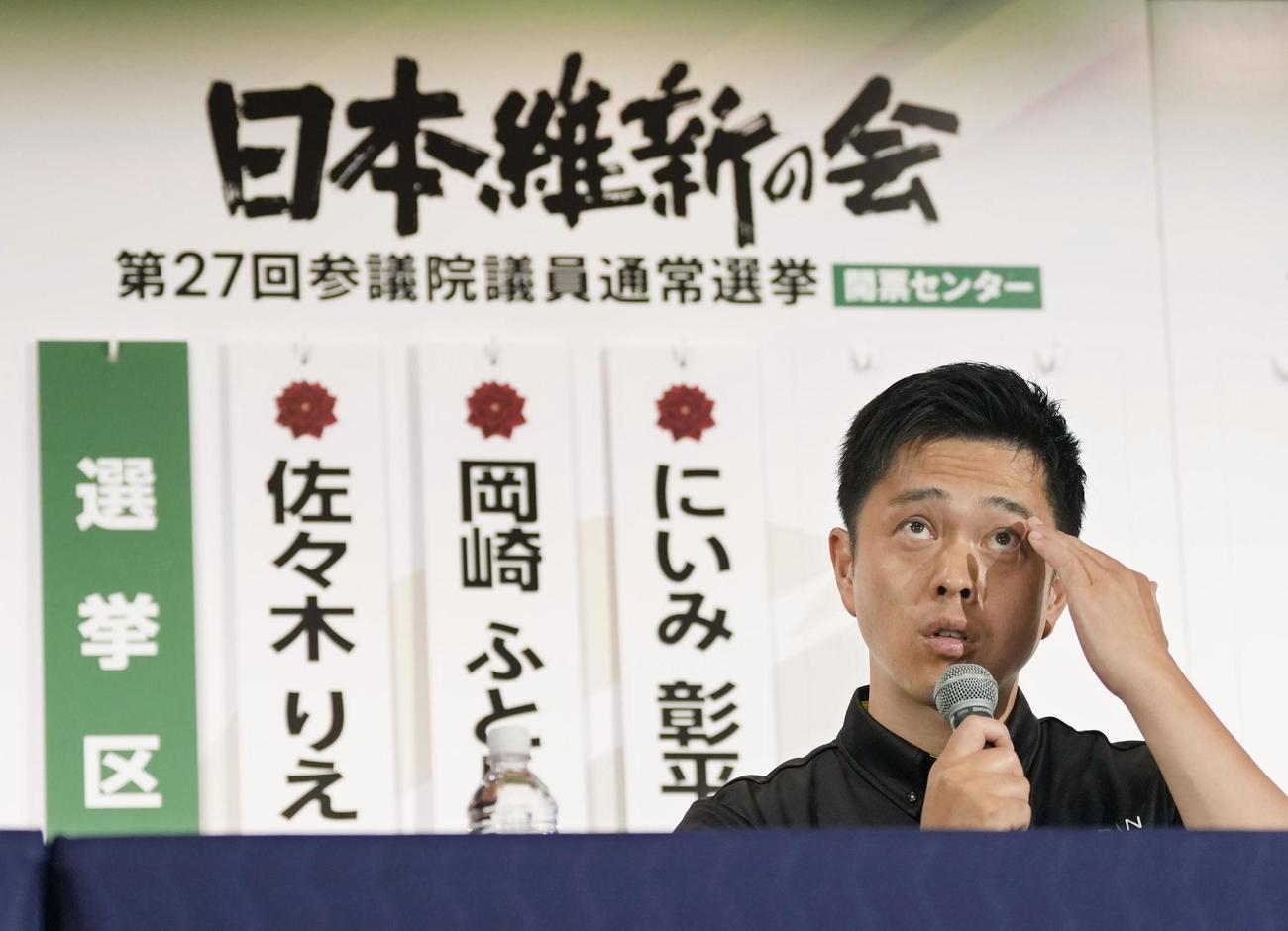 記者会見で額に手をやる日本維新の会の吉村代表（共同）