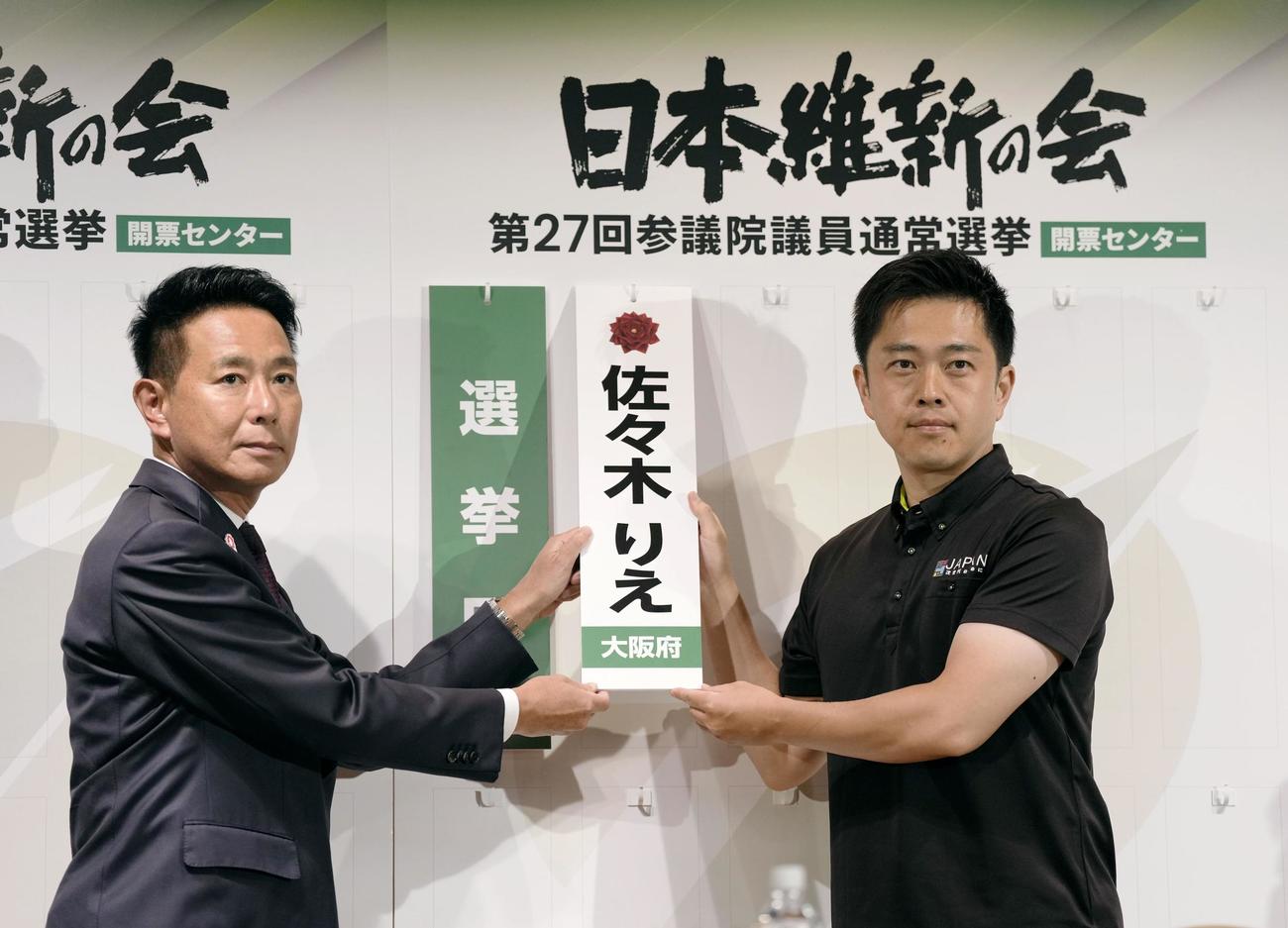 当確者の名札をかける日本維新の会の吉村代表（右）と前原共同代表（共同）
