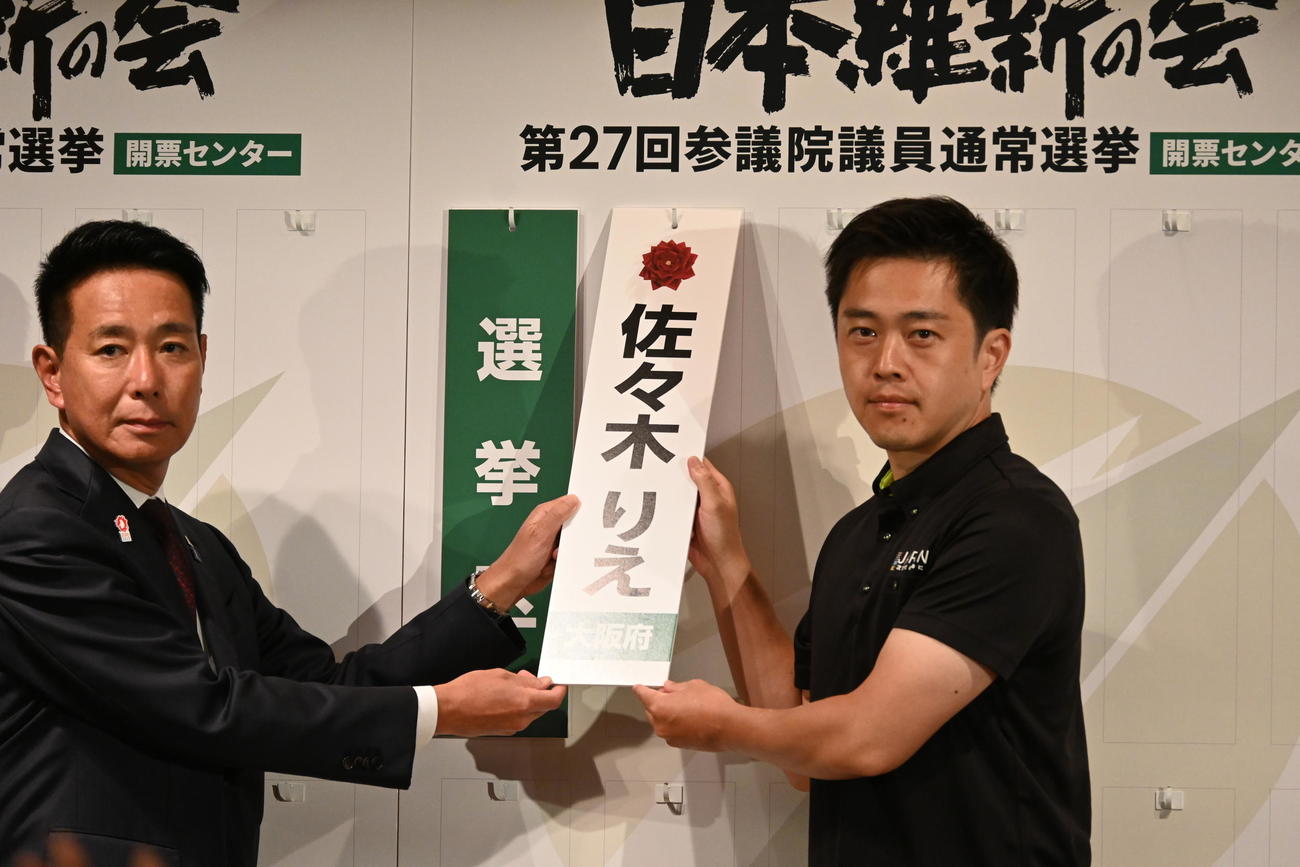 大阪市内のホテルで当選確実となった候補者のボードを持つ吉村洋文代表（右）前原誠司共同代表（撮影・松浦隆司）