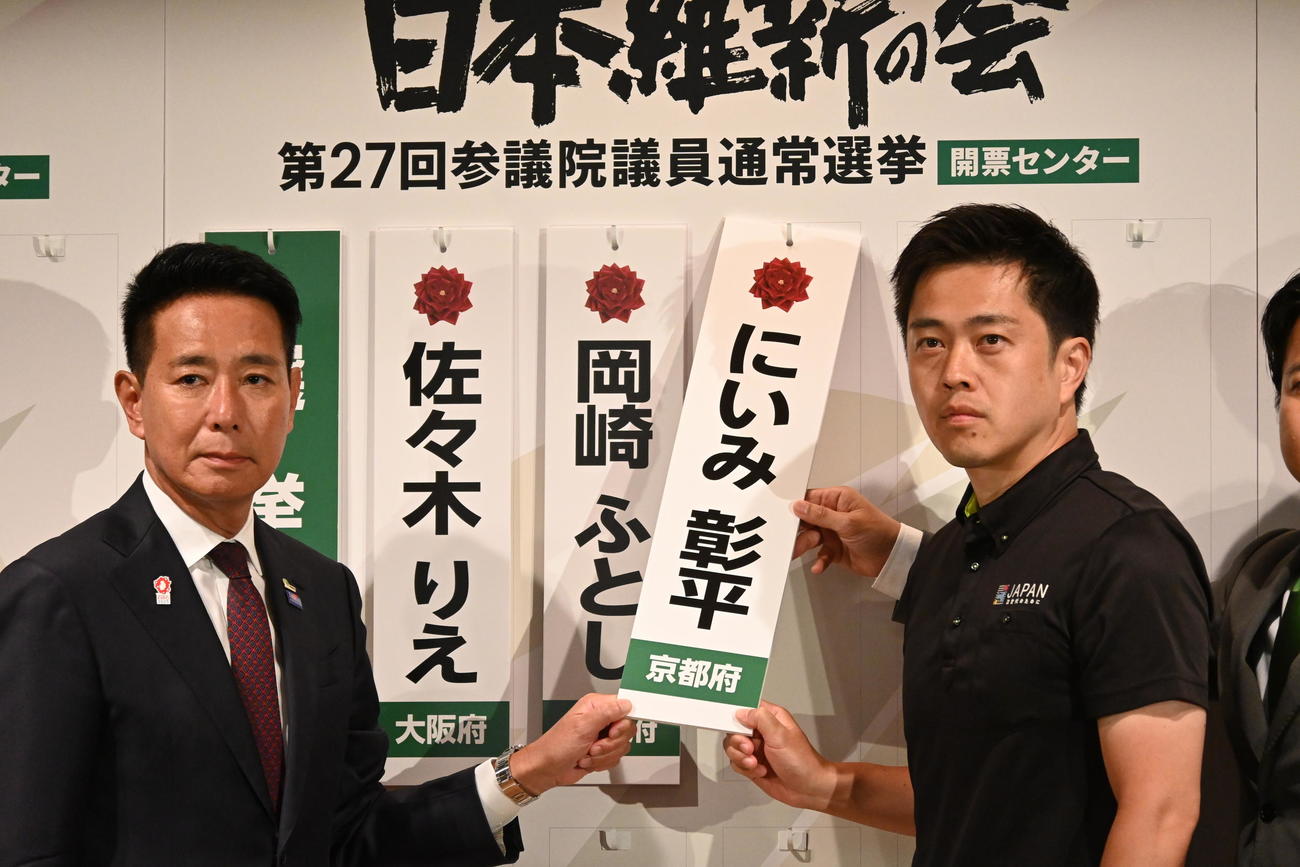 大阪市内のホテルで当選確実となった候補者のボードを持つ吉村洋文代表（右）前原誠司共同代表（撮影・松浦隆司）