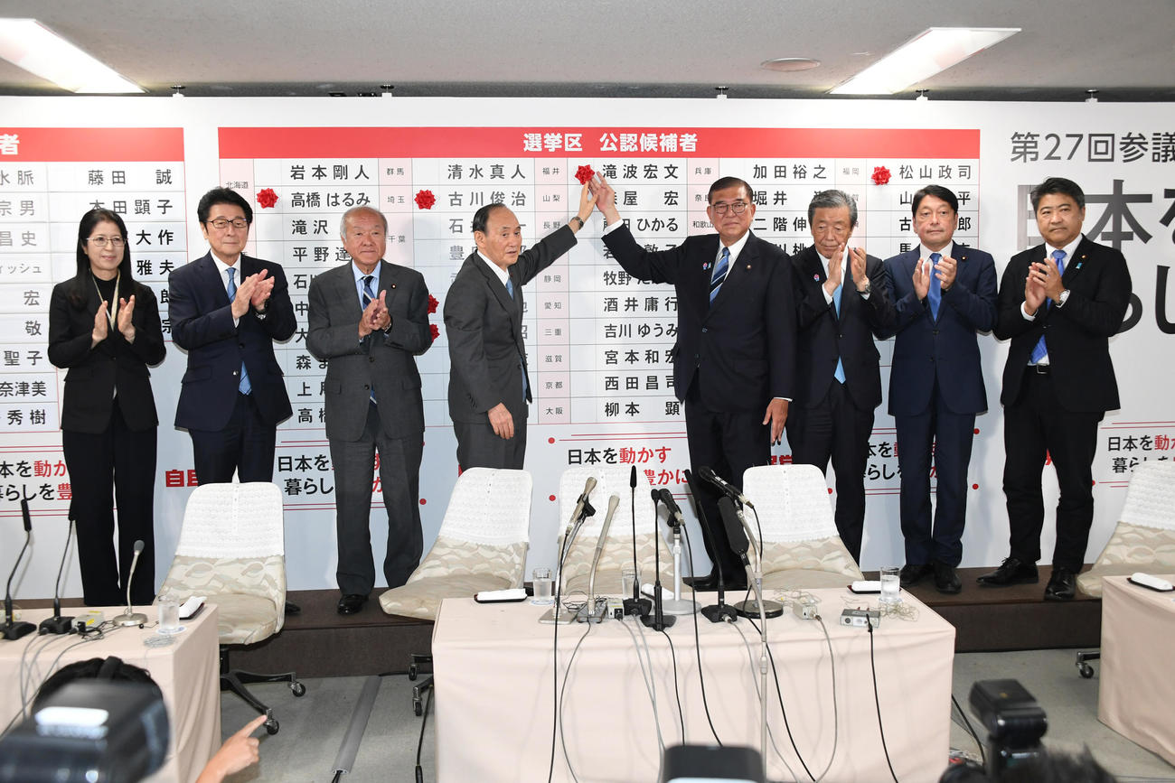 自民党総裁の石破茂首相（右から4人目）は当確者の名前にバラを付ける（代表撮影）