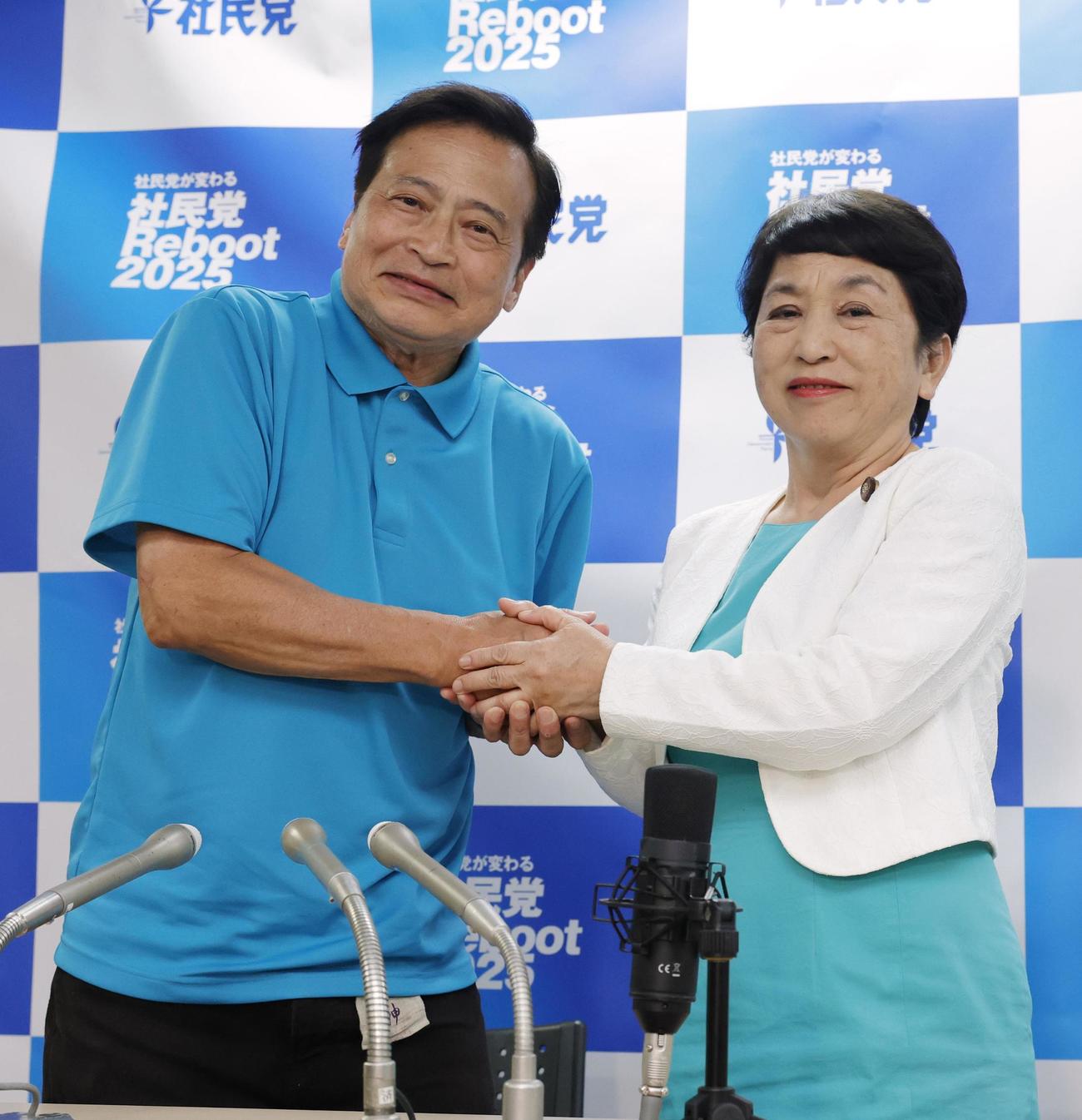 比例代表で当選を決めたラサール石井氏（左）と握手する社民党の福島党首（共同）