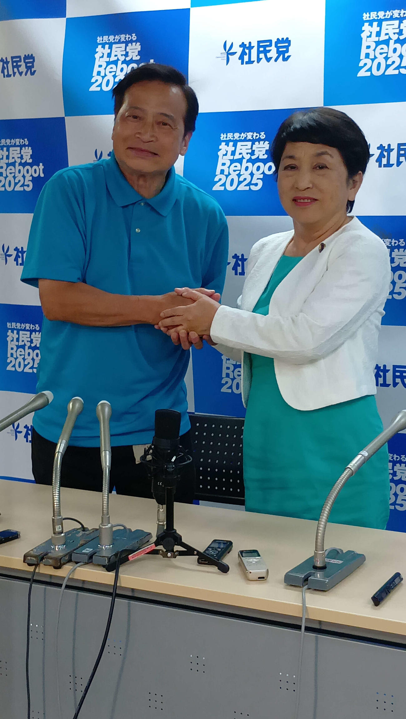 午前4時過ぎにNHKの当確が出て、会見で、ラサール石井氏（左）は福島瑞穂社民党党首とガッチリ握手