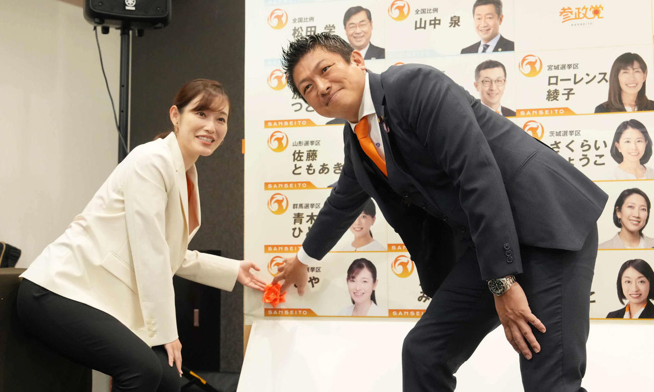 参院選東京選挙区での当選を確実にし神谷代表（右）と花付けをする参政党さや議員（2025年7月19日撮影）