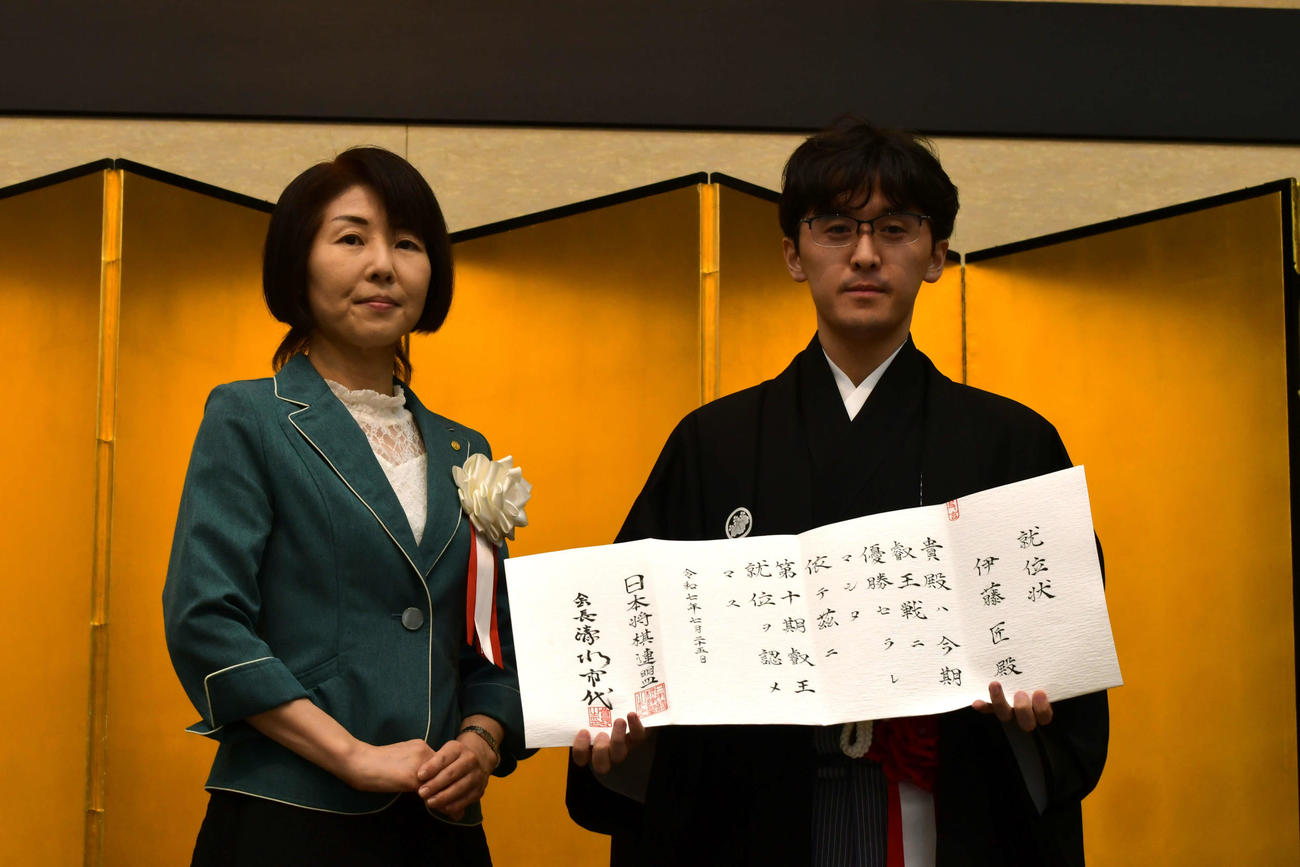 日本将棋連盟の清水市代会長（左）から渡された就位状を手にする伊藤匠叡王