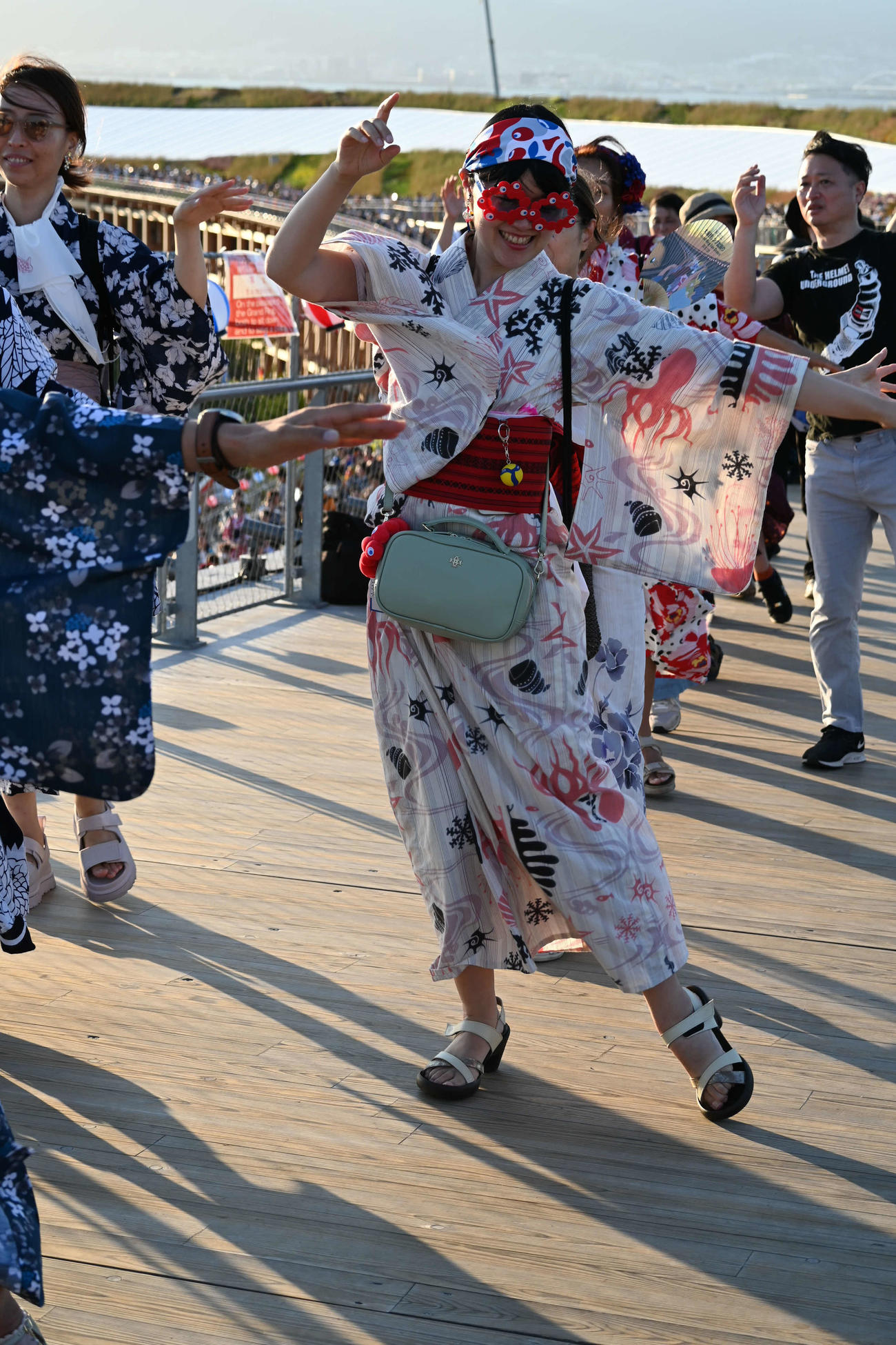 大屋根リングの盆踊りにミャクミャクの「メガネ」をかけて参加する女性も（撮影・松浦隆司）