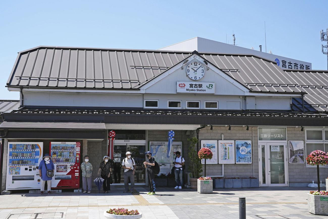 津波警報が発令され、運行が停止された岩手県宮古市の三陸鉄道宮古駅前でたたずむ人たち（共同）