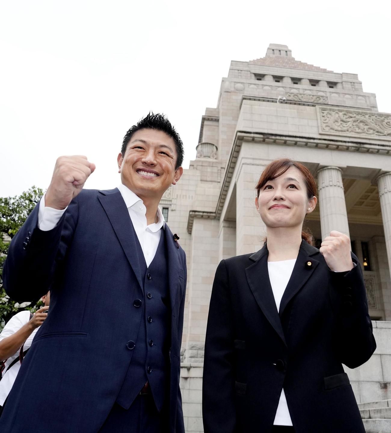国会に初登院し、参政党の神谷代表（左）とポーズをとる塩入清香参院議員（共同）