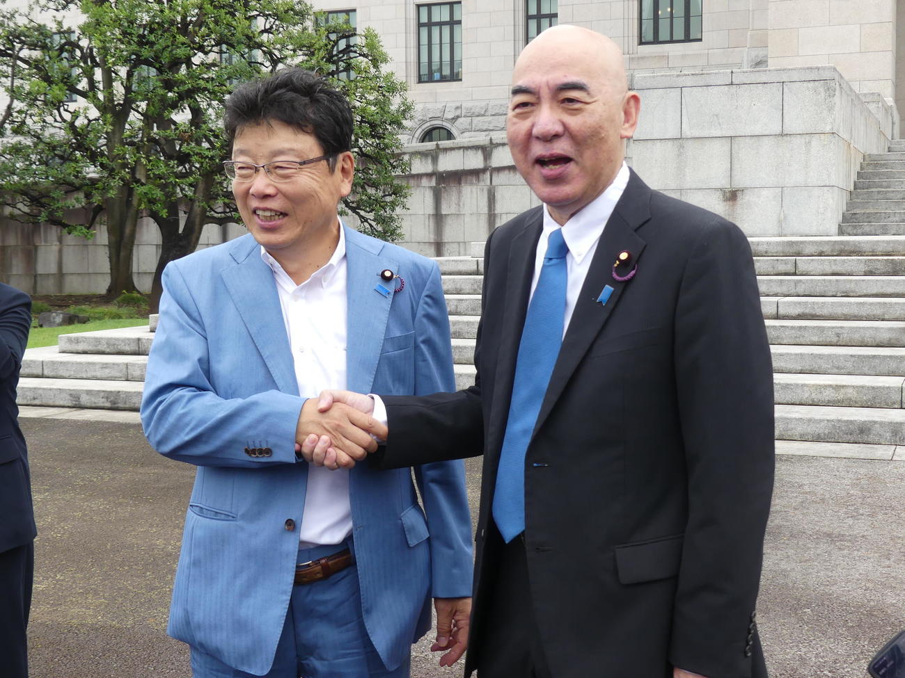 臨時国会が召集された国会に初登院し、メディアの求めに応じて握手を交わす日本保守党の北村晴男参院議員（左）と百田尚樹参院議員（撮影・中山知子）