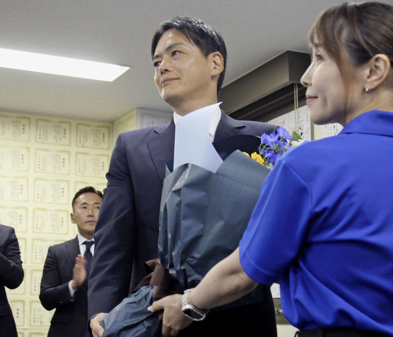 横浜市長選で当選が決まり、花束を受け取る山中竹春氏（右から2人目）（共同）