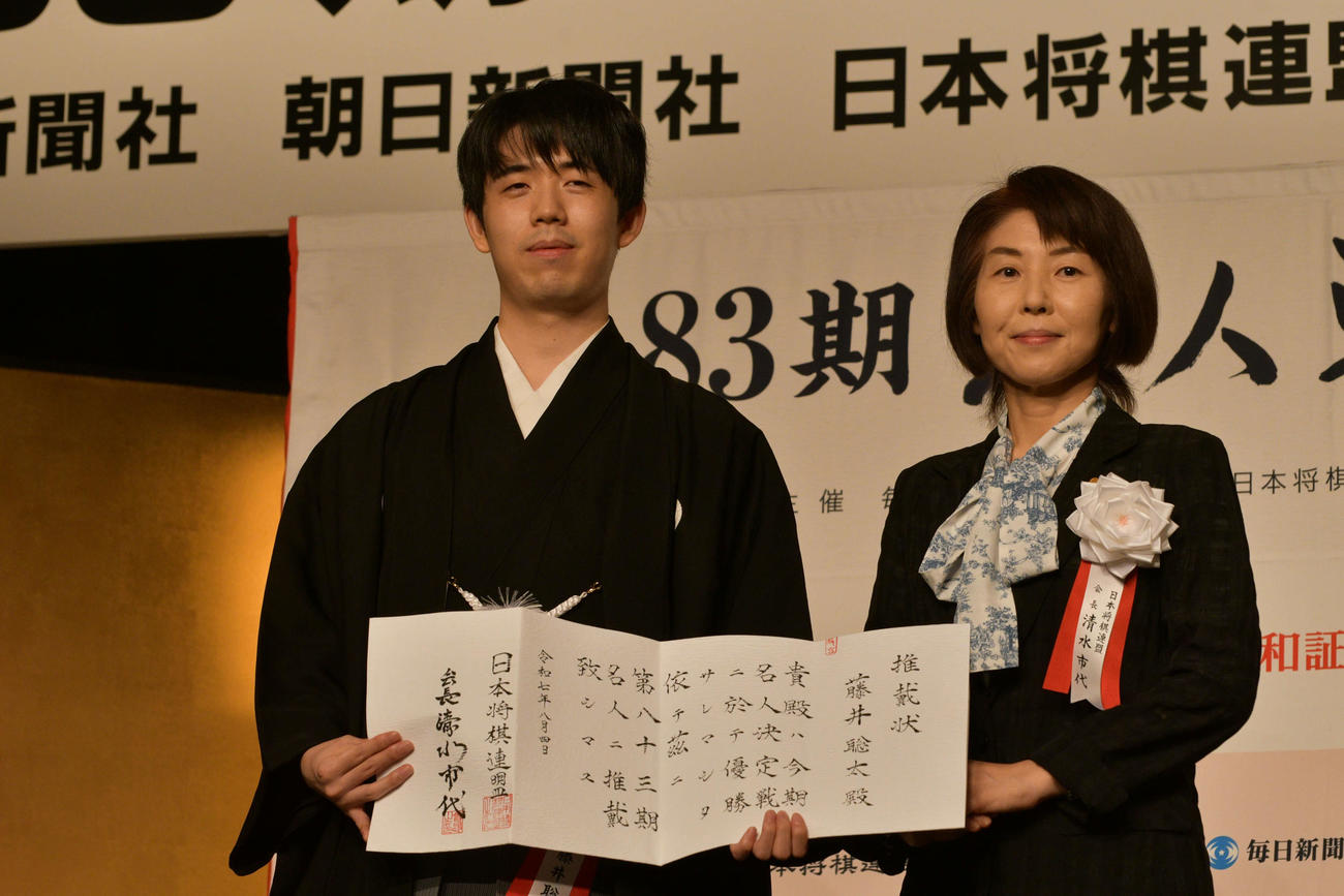 名人就位式で推戴状を手にする藤井聡太名人（左）、日本将棋連盟の清水市代会長