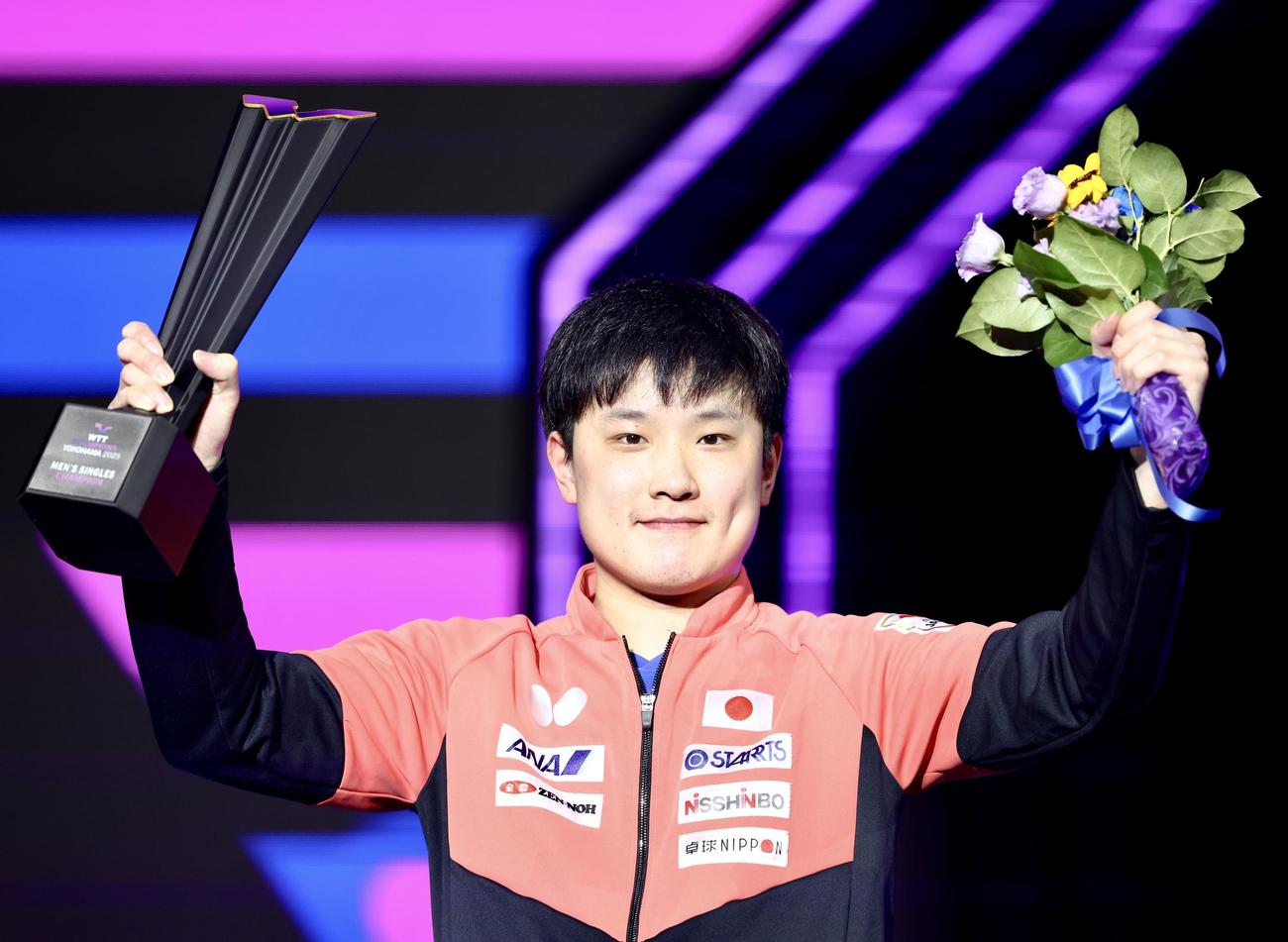 男子優勝を果たし、トロフィーを手に写真に納まる張本（撮影・河田真司）
