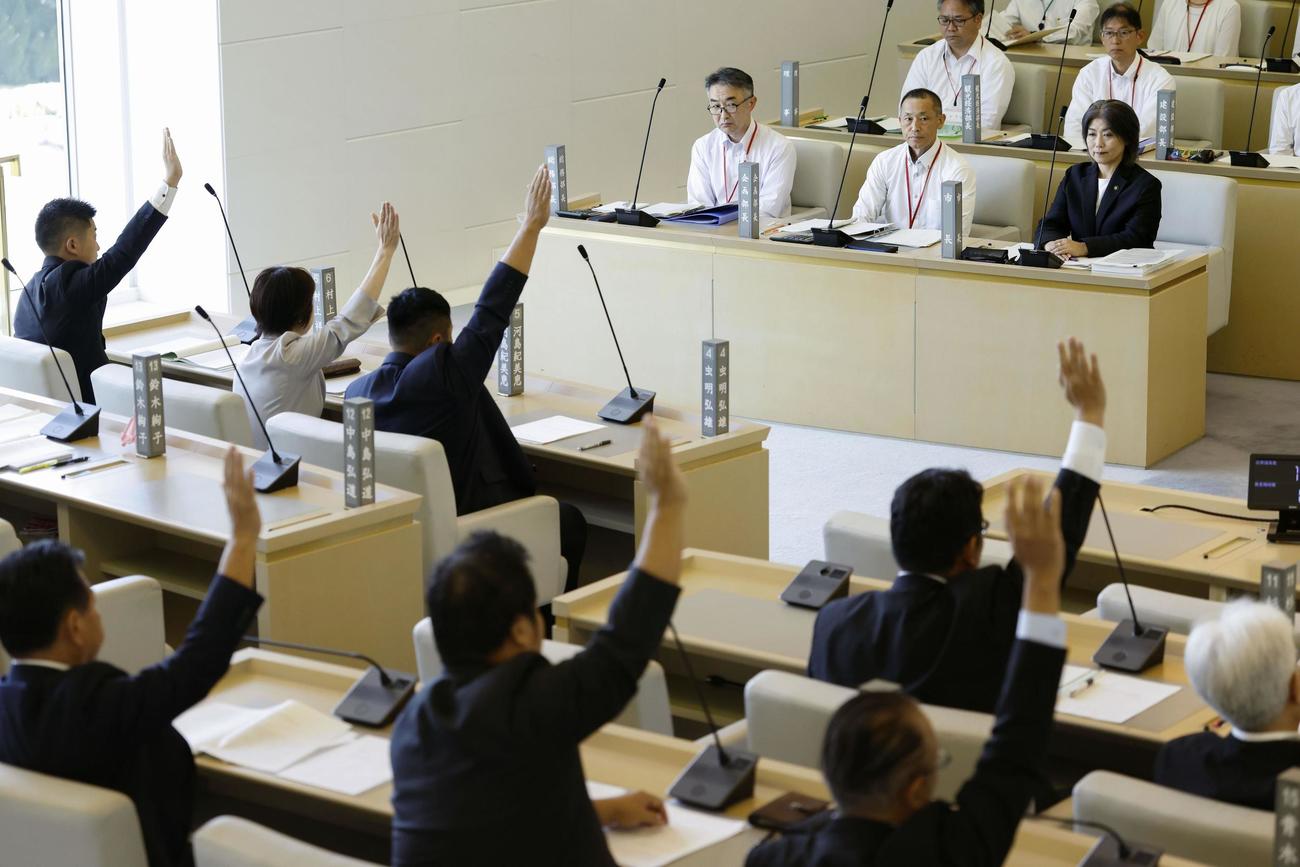 静岡県伊東市議会本会議で、自身への刑事告発などに関する採決を見守る田久保真紀市長（上前列右）＝1日午前（共同）