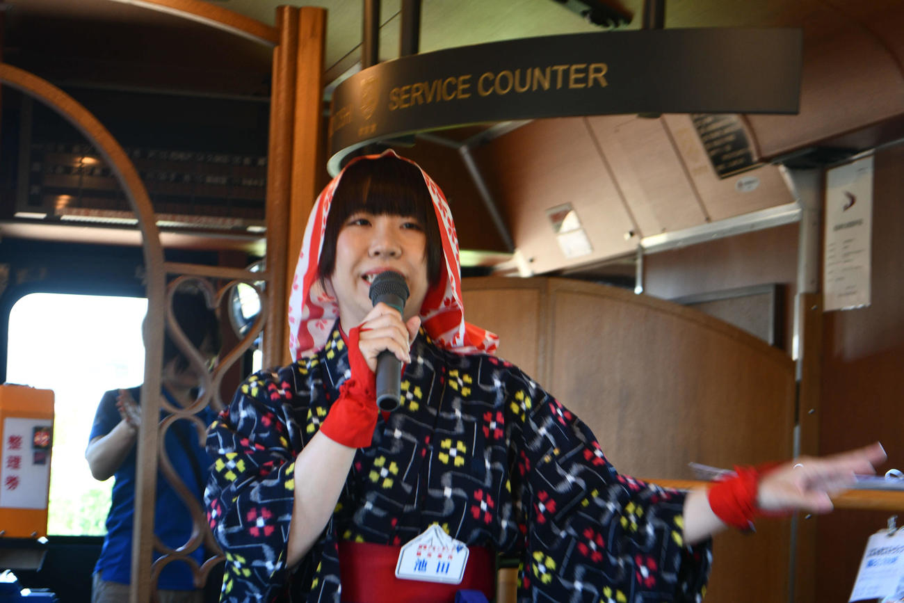 沿線のガイドをする「秋田おばこ」姿の列車アテンダント