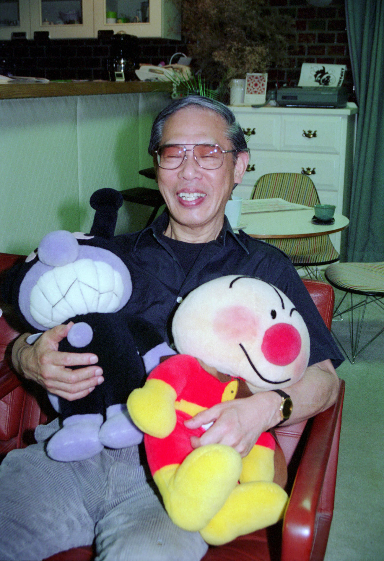 91年、アンパンマンのぬいぐるみを手に、笑顔のやなせたかしさん