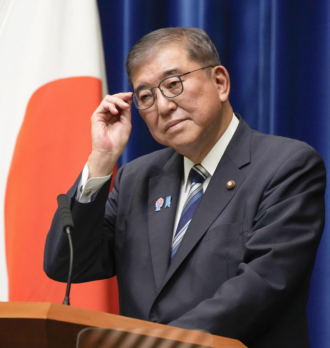 記者会見で質問を聞く石破首相（共同）