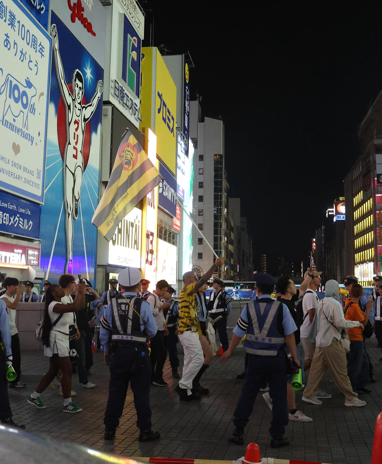 阪神の旗を持って道頓堀を歩くファン（撮影・白石智彦）