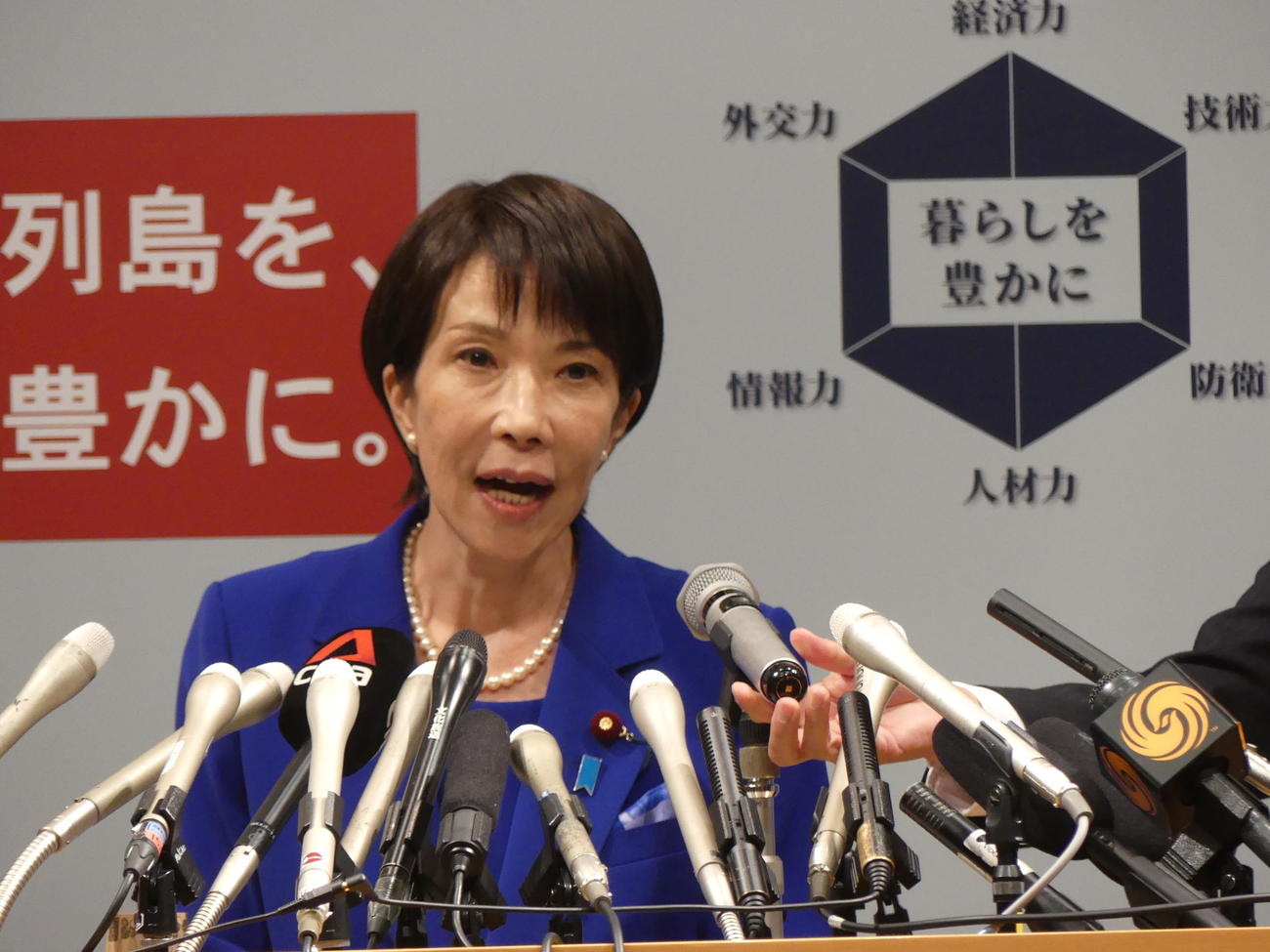 政策発表会見冒頭、マイクトラブルに見舞われ、スタッフが調整する中政策を訴える高市早苗・前経済安保担当相