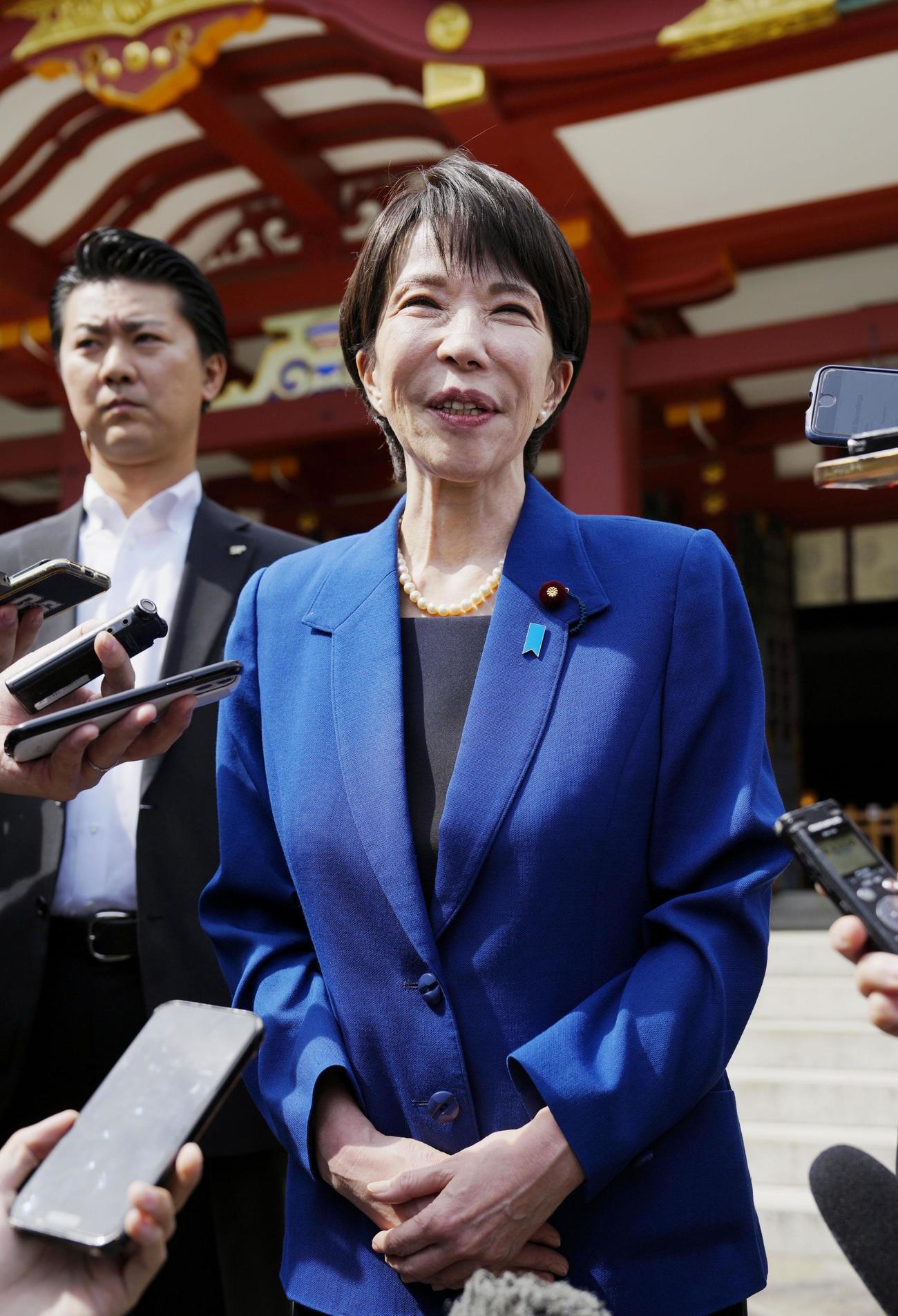 日枝神社を参拝し、記者団の取材に応じる高市前経済安保相＝22日午前10時35分、東京・永田町（共同）