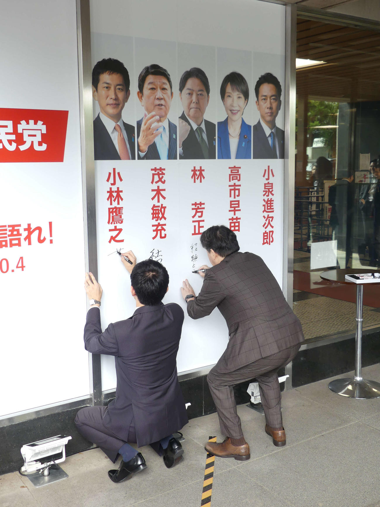 自民党本部に設置されたボードに総裁選への思いを書き込む小林鷹之・元経済安保担当相（左）と林芳正官房長官（撮影・中山知子）