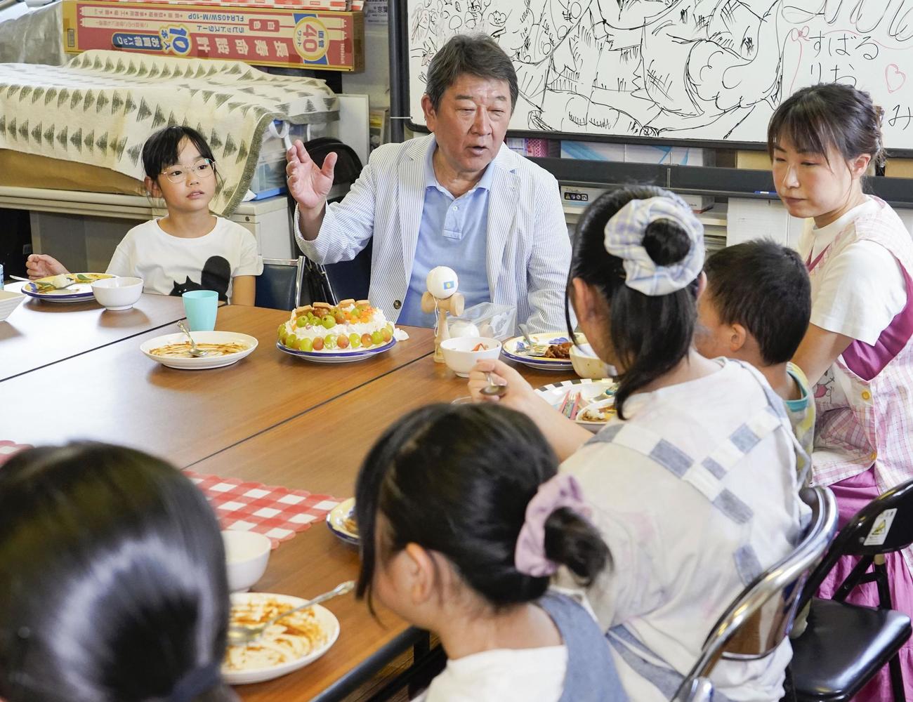 子どもたちと食事をしながら話す自民党の茂木前幹事長（共同）