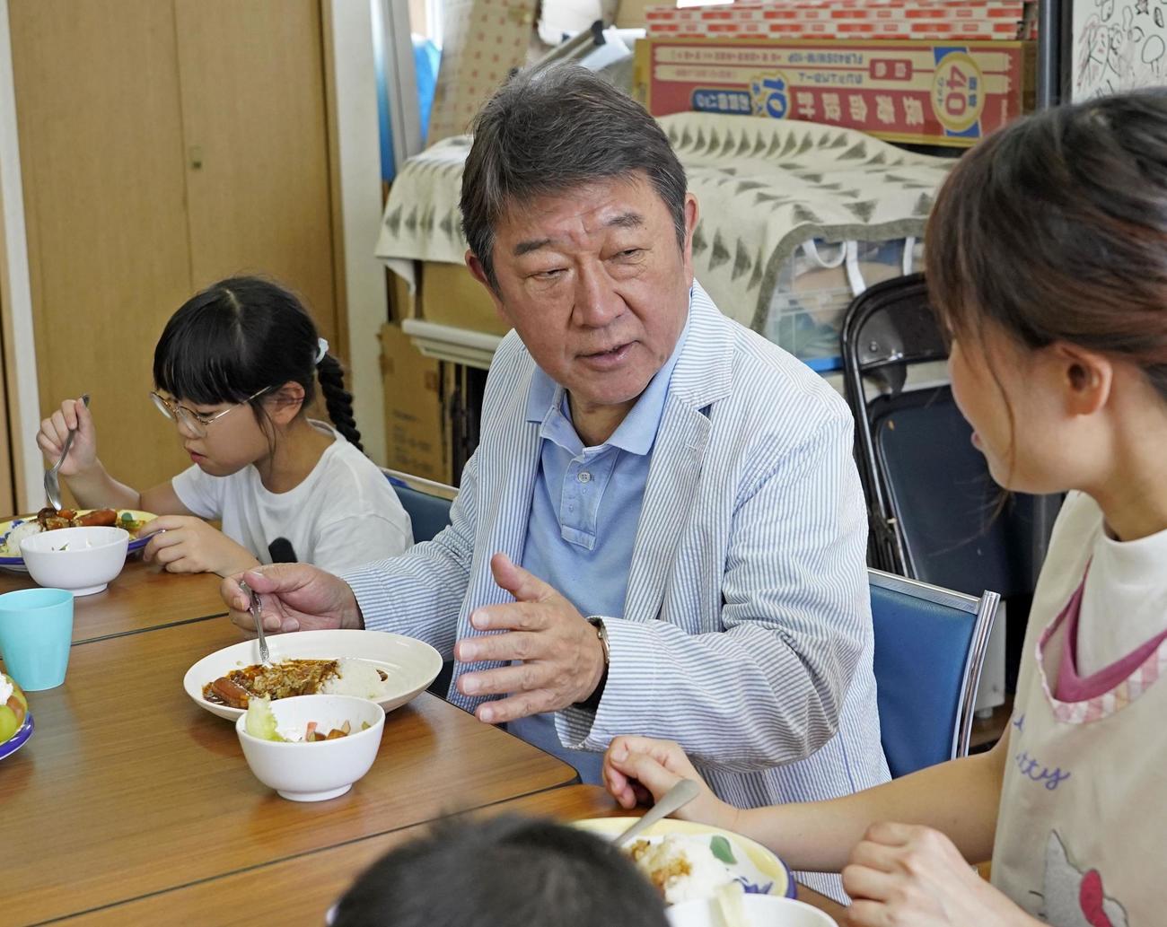 子どもたちと席を並べて食事をする自民党の茂木前幹事長（共同）