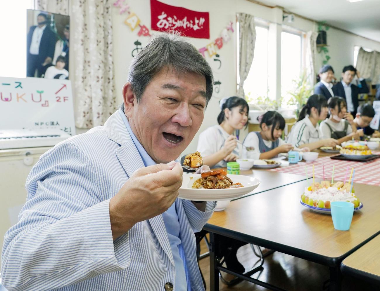 子ども食堂を視察し、カレーライスを食べる自民党の茂木前幹事長（共同）