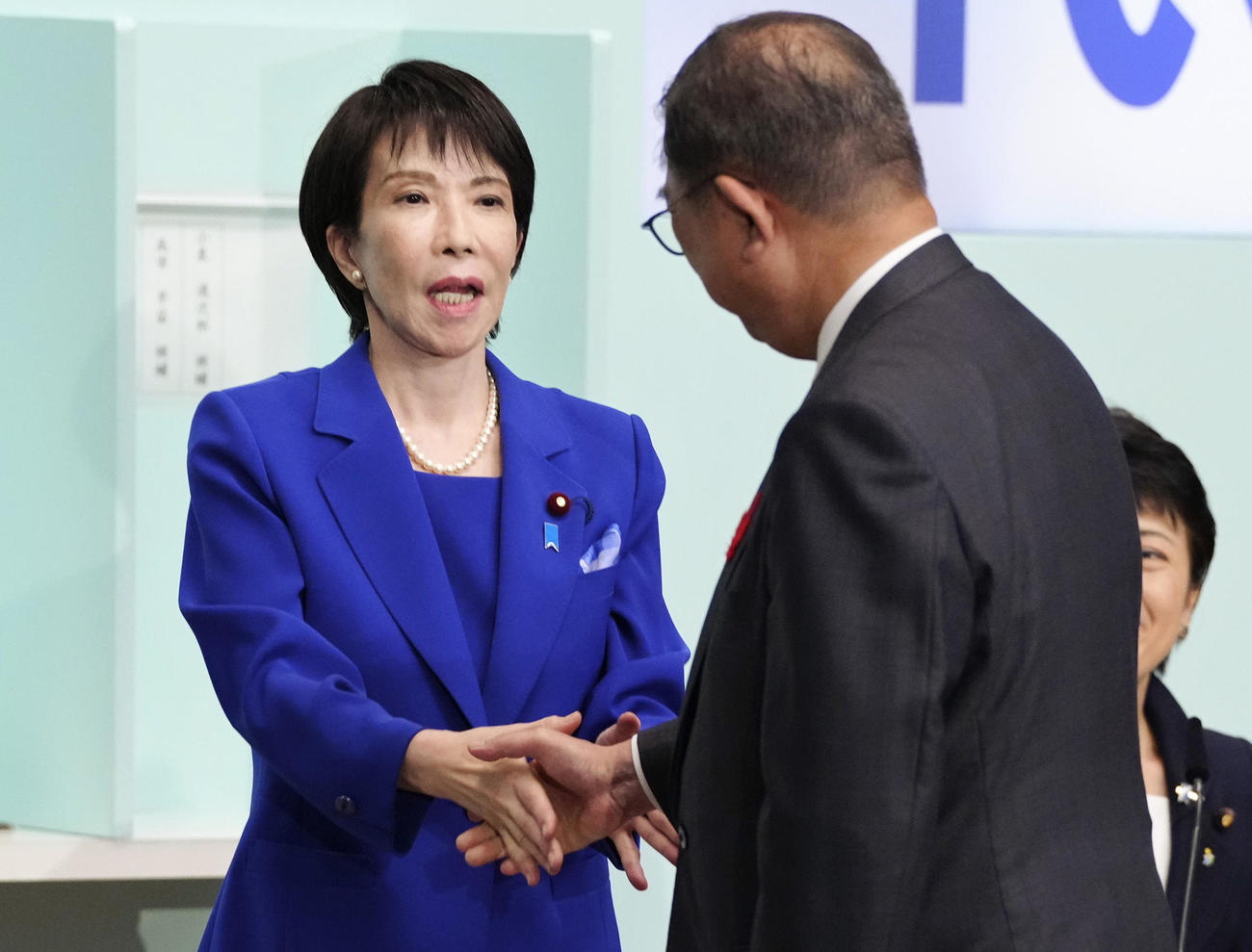 自民党総裁選後に開かれた両院議員総会で石破首相（右）と握手する高市早苗新総裁（共同）