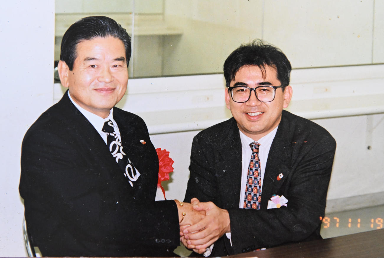 97年、川淵三郎氏（左）と握手する溝畑宏氏